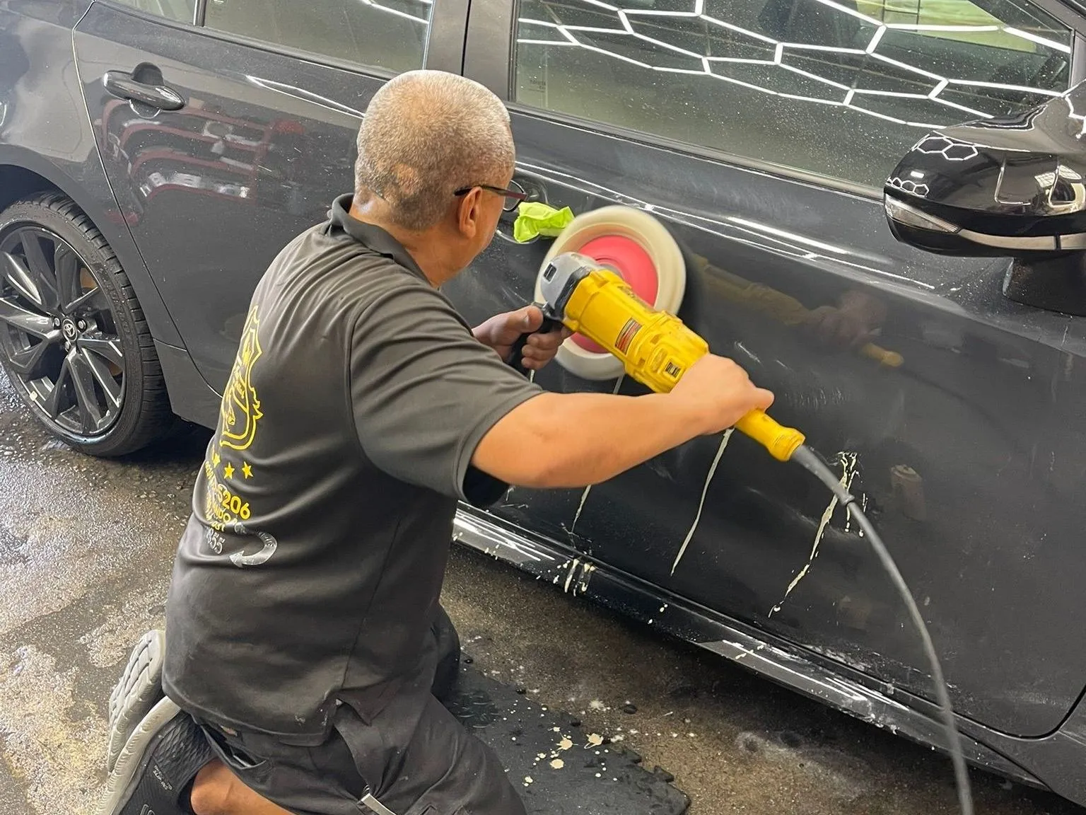 Machine polishing a sedan inside the Chinto Auto Detailing shop, Northridge