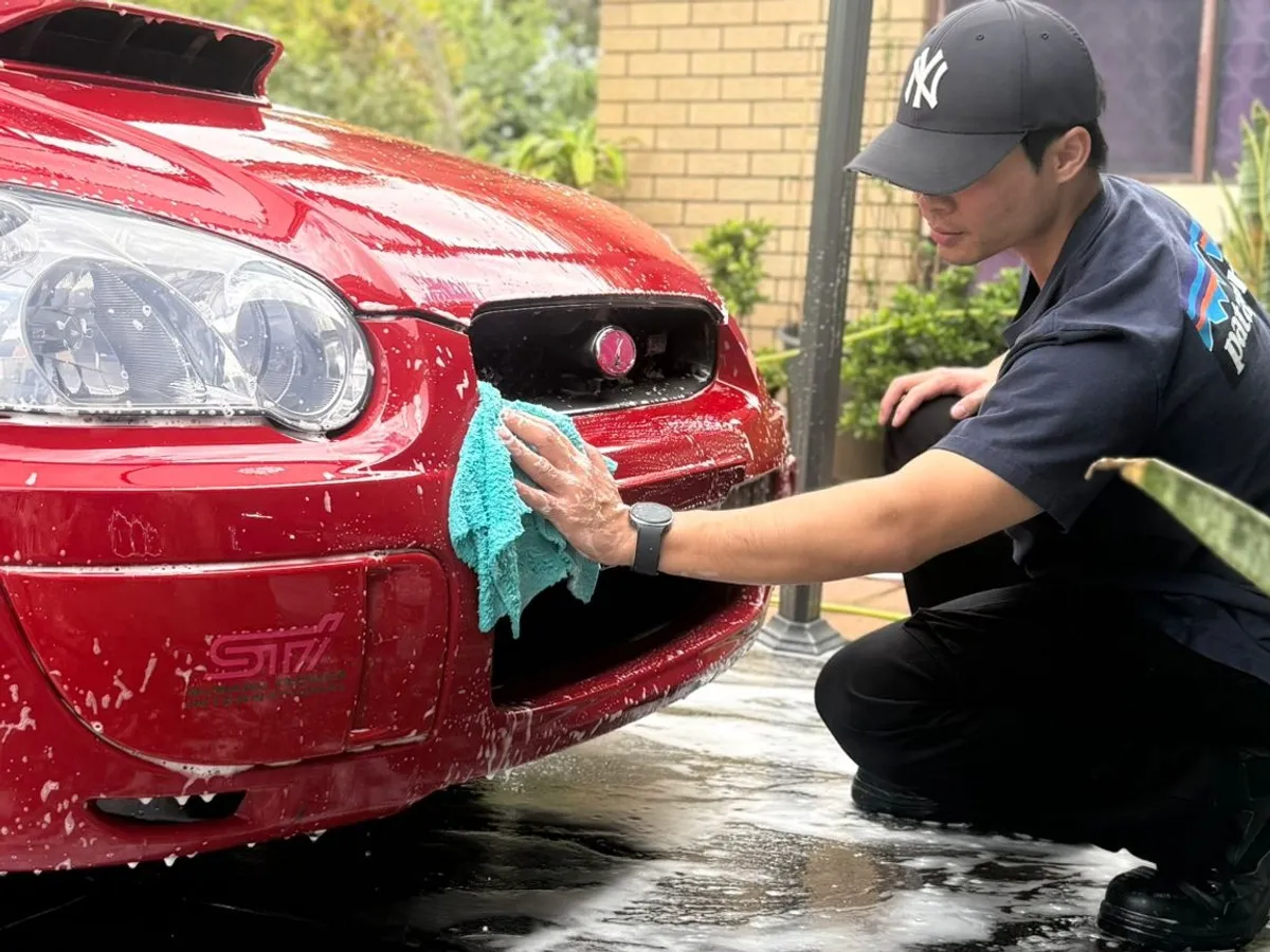 Hand washing the front bumper of a Subaru WRX at DriveHQ Detailing Co. in Dianella