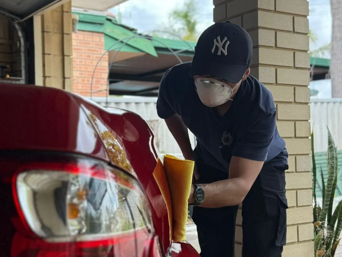 Quoc working the rear quarter of a Subaru WRX at DriveHQ Detailing Co. in Dianella