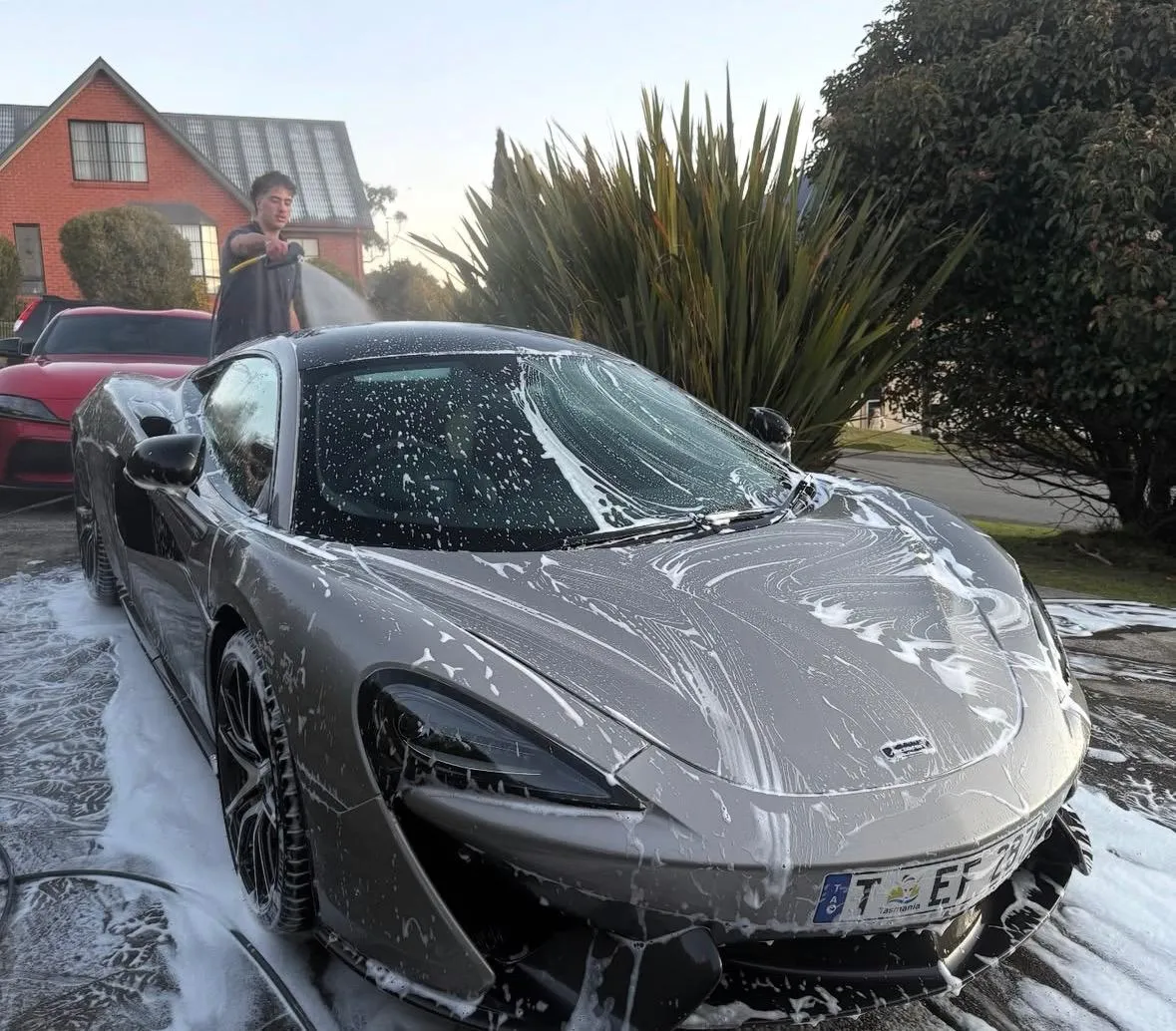 Josh from Van Diemen Detailing washing a McLaren in Hobart